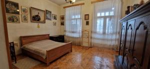Un dormitorio con una cama y una ventana grande. en Beautiful 2-room apartment hosted by a Georgian Artist, en Tiflis