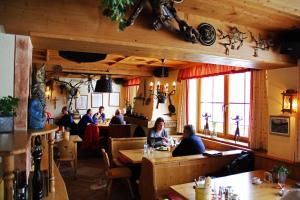 een groep mensen die aan tafels in een restaurant zitten bij Hotel Garni - Restaurant Kaminstube in Sankt Anton am Arlberg