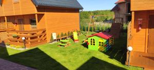 a toy yard with a toy house and a playground at Słoneczny Przystanek in Jarosławiec