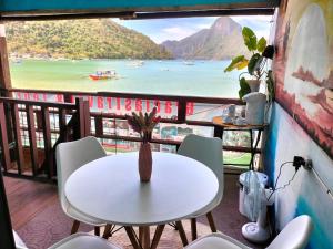 a table and chairs on a balcony with a view of the ocean at Gracias Place in El Nido