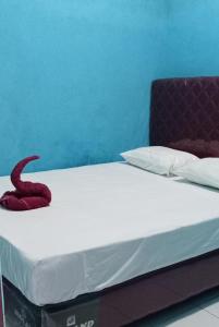 Una cama con una serpiente roja encima. en Raja Ampat Sandy Guest House en Saonek