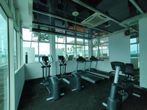 a gym with treadmills and ellipticals in a room with windows at reSTARY - K Universe, Sutera Avenue Infinity Pool - Imago Opposite - KK City- 3BR,10Pax 来沙旅 K歌宇宙主题公寓 - 无边际日落海景泳池 - Imago商场对面 - KK市中心 - 3房10人 in Kota Kinabalu