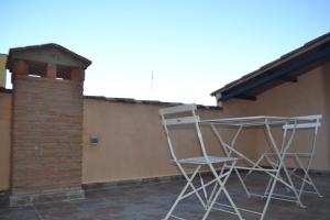 une paire de chaises assises sur le côté du bâtiment dans l'établissement Caleros 8 Apartamento - Apartamentos de la Parte Antigua de Cáceres, à Cáceres