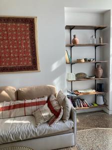 een woonkamer met een bank en een boekenplank bij L'Oasis de La Roquette in Arles