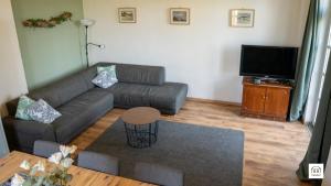 a living room with a couch and a flat screen tv at Ferienhaus Fristerhof in Keeken