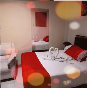 ein Hotelzimmer mit 2 Betten und Handtüchern darauf in der Unterkunft Hotel Nevada in Cali
