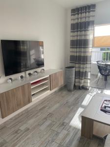 a living room with a flat screen tv on a wall at Cozy apartment in Los Cristianos in El Guincho