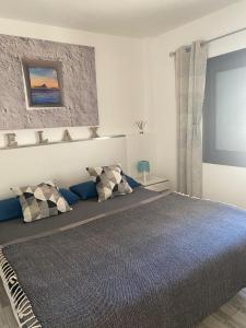 a bedroom with a large bed with two pillows at Cozy apartment in Los Cristianos in El Guincho