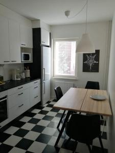 a kitchen with a wooden table and chairs in a kitchen at Parvekkeellinen huoneisto rantabulevardilla, 1-4 hengelle in Savonlinna