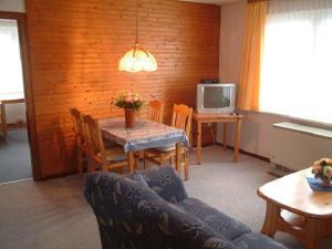 een woonkamer met een tafel en stoelen en een televisie bij Haus Reni in Büsum