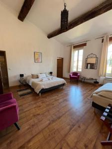 1 dormitorio grande con 1 cama y suelo de madera en Domaine De La Tannerie chambres d'hôtes et appartements, en Prades