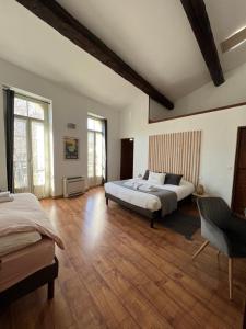 - une grande chambre avec 2 lits et du parquet dans l'établissement Domaine De La Tannerie chambres d'hôtes et appartements, à Prades