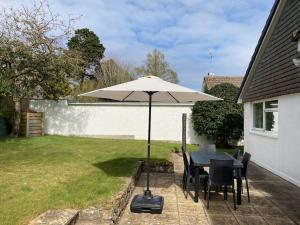 a table with an umbrella in a yard at Penzance- West Cornwall seaside getaway in Penzance