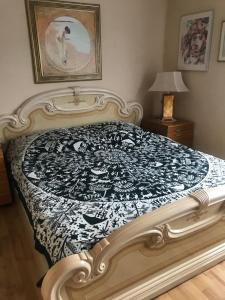a bed with a black and white quilt on it at Ferienwohnung Rogi in Bad Wildungen