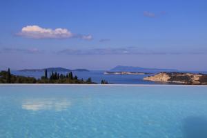 a large body of blue water with trees in the distance at Sunset Sea View Villa 10 in Afionas