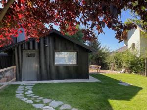 a garden rendering of a black house with a walkway at Los Coirones 3 - Cabaña con jardin in Dina Huapi
