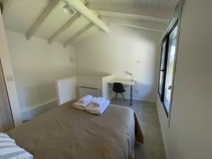 1 dormitorio con 1 cama con 2 toallas en Cabaña con jardin en Dina Huapi
