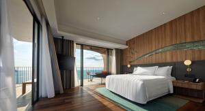 a bedroom with a bed and a view of the ocean at PARKROYAL Langkawi Resort in Pantai Cenang