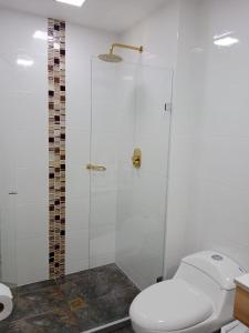 y baño con aseo y ducha acristalada. en Medellin apartamento en laureles, en Medellín