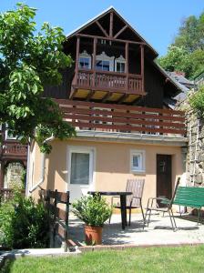 ein Haus mit einem Balkon und einem Tisch davor in der Unterkunft Wehlener Landhaus in Stadt Wehlen, Sächsische Schweiz in Stadt Wehlen