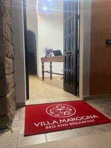 a red welcome mat in front of a door at Villa Marogna in Alghero