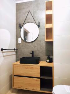 a bathroom with a black sink and a mirror at Apartament DanHouse in Giżycko