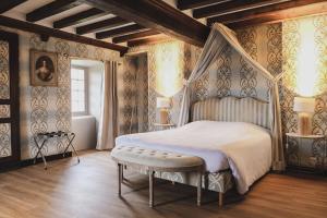 - une chambre avec un lit à baldaquin et une fenêtre dans l'établissement Le Château de la Roque-Logis Hôtels, à Hébécrevon