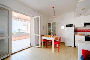 a kitchen and dining room with a table and a view of the ocean at Appartamento a 20mt dal mare con piscina condominiale in Marcelli +1 photo