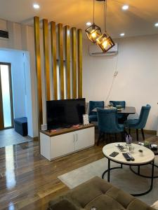 a living room with a couch and a tv and a table at Apartman 3M Lux in Vrnjačka Banja