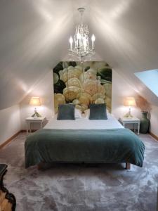 a bedroom with a large bed with a painting on the wall at Au chant des oiseaux in Le Torquesne