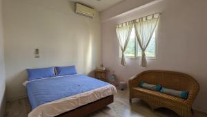 a bedroom with a bed and a chair and a window at Tien Chon Xiao Lin Homestay in Jiaoxi