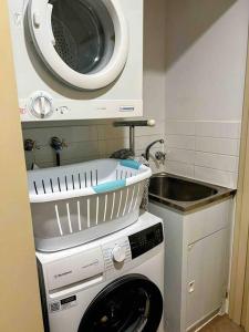 a kitchen with a washing machine and a microwave at Modern 2 Bed Apartment - Oaks Resort, Cable Beach in Cable Beach