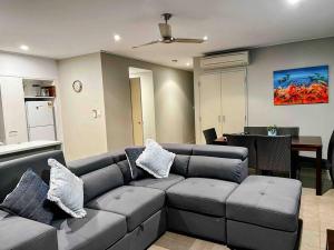 a living room with a couch and a dining room at Modern 2 Bed Apartment - Oaks Resort, Cable Beach in Cable Beach
