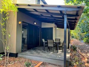 a patio with a table and chairs under a pergola at Modern 2 Bed Apartment - Oaks Resort, Cable Beach in Cable Beach