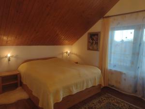 um quarto com uma cama e uma janela em Apartvilla Serbota em Porumbacu de Sus