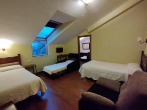 a hotel room with two beds and a couch at Hotel Rural Corazón de las Arribes in Aldeadávila de la Ribera