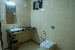 a bathroom with a toilet and a sink at Flamingo Club and Resort Una 3 Km Away from Diu Check Post in Diu