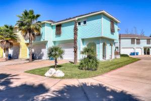 a blue house with palm trees in front of it at Beachy Keen in Port Aransas