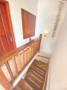 eine Holztreppe mit einer Holztür und einer Treppe in der Unterkunft Samburá Paraty in Paraty