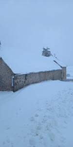 una pared en la nieve con huellas en la nieve en Le petit gîte des 4 saisons en Cézens