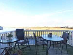 Bagenkopにある8 person holiday home in Bagenkopの海を望むバルコニー(テーブル2台、椅子付)