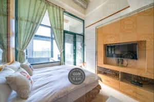 Schlafzimmer mit einem Bett, einem TV und einem Fenster in der Unterkunft 泉泉溫泉民宿 in Jiaoxi