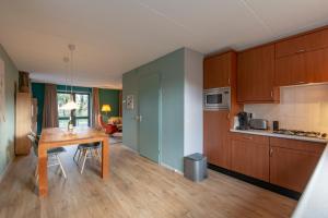 a kitchen with wooden cabinets and a wooden table at Villa Duynopgangh 46 Julianadorp aan Zee in Julianadorp
