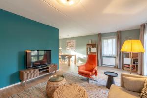 a living room with a couch and a tv at Villa Duynopgangh 46 Julianadorp aan Zee in Julianadorp