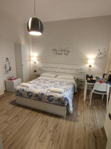 ein Schlafzimmer mit einem Bett, einem Schreibtisch und einem Tisch von sidx sidx sidx in der Unterkunft Blue Rose Private Room in Salerno