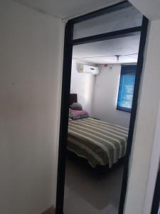 Habitación pequeña con cama y espejo. en HABITACION PARA DOS PERSONAS en Barranquilla
