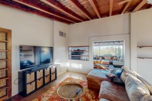 uma sala de estar com um sofá e uma televisão de ecrã plano em Cactus Grove Main House em Tucson