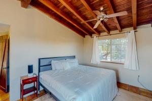 um quarto com uma cama e uma ventoinha de tecto em Cactus Grove Main House em Tucson