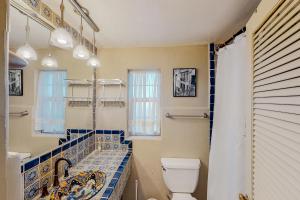 uma casa de banho com WC e azulejos azuis e brancos. em Cactus Grove Main House em Tucson