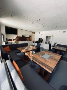 Gästehaus Hoamat'l في باخ: غرفة معيشة مع طاولات خشبية وأريكة